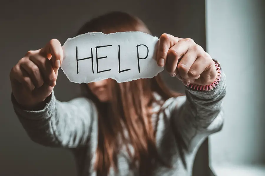 girl holding help sign